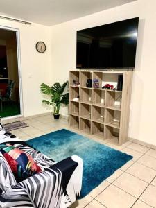 ein Wohnzimmer mit einem Sofa und einem TV in der Unterkunft Studio Papeete Lodge - Kaoha Nui in Papeete