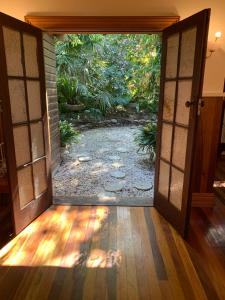 una puerta abierta con un jardín visto a través de ella en Garden studio, en Glenbrook