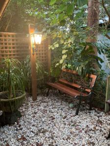 un banco en un jardín con una lámpara y plantas en Garden studio, en Glenbrook