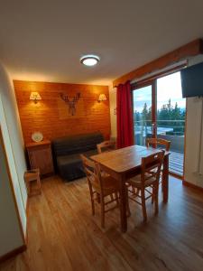 a dining room with a table and chairs and a couch at Silènes B33 à Chamrousse 1700 aux Domaines de l'Arselle in Chamrousse