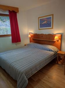 a bedroom with a large bed with a wooden headboard at Silènes B33 à Chamrousse 1700 aux Domaines de l'Arselle in Chamrousse