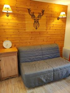 a bedroom with a bed and a wall with a stag head at Silènes B33 à Chamrousse 1700 aux Domaines de l'Arselle in Chamrousse +4 photos