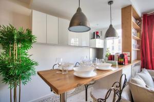 una cocina con una mesa de madera con platos y vasos. en Studio Republique Pierre Levé en París