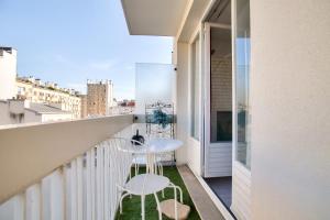 einen Balkon mit zwei Stühlen und einem Tisch darauf in der Unterkunft Studio Republique Pierre Levé in Paris