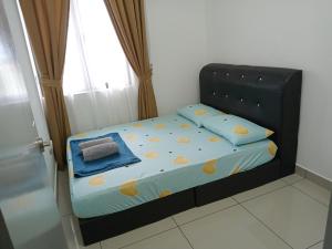 a small bed in a room with a window at FZ Almyra Homestay in Kajang