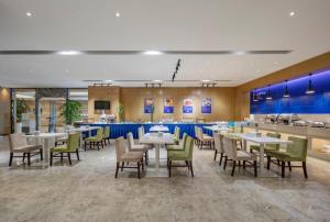a restaurant with tables and chairs and a bar at Holiday Inn Express Shanghai New Jinqiao, an IHG Hotel in Shanghai