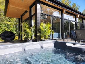 a swimming pool in a house with windows at Les Chalets Double K # 1 in Saint-Alexis-des-Monts