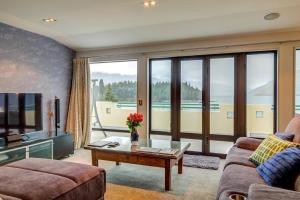 a living room with a couch and a table and a tv at Lakefront Luxury Penthouse central Queenstown in Queenstown