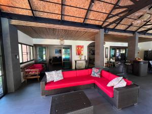 una sala de estar con un sofá rojo en una habitación en Coral Beach Pool Villa Khao Lak - SHA Extra Plus en Khao Lak