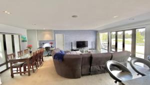 a living room with a couch and a dining room at Lakefront Luxury Penthouse central Queenstown in Queenstown