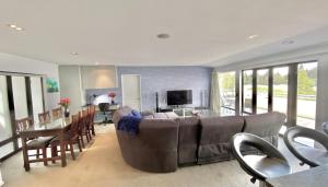 un soggiorno con divano e sala da pranzo di Lakefront Luxury Penthouse central Queenstown a Queenstown