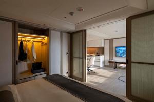 a bedroom with a bed and a desk in a room at Hanns House in Taipei