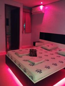 um quarto com uma cama com iluminação rosa em Hotel cowboy Cidade Dutra em São Paulo