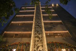 un edificio alto con flores en las ventanas por la noche en DLR GRAND en Tirupati