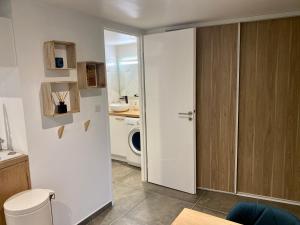 a bathroom with a door open to a kitchen at 220 Le Studio in Pradons