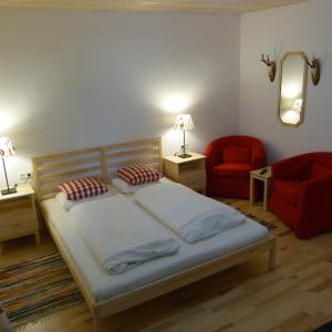 a bedroom with a bed and a red chair at Jägerchalet in Uttendorf