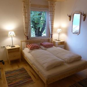 a bedroom with a bed with two lamps and a window at Jägerchalet in Uttendorf