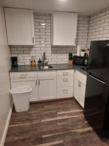 a kitchen with white cabinets and a black refrigerator at Born to Wander in Cedar City