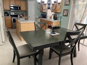 una mesa de comedor negra con sillas y una cocina en Nature Friendly en White City