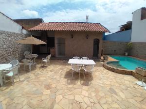 une terrasse avec une table, des chaises et une piscine dans l'établissement CASA MATTOS, à São Pedro da Aldeia