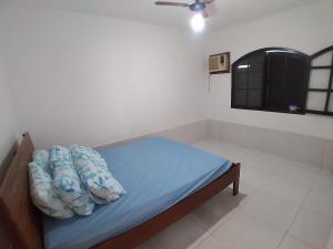Cama pequeña con sábanas azules y almohadas en una habitación en CASA MATTOS en São Pedro da Aldeia