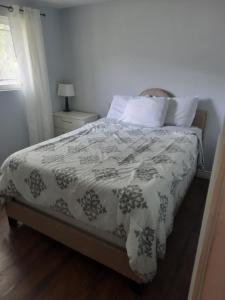 a bedroom with a bed with a blanket and pillows at Never Stop Exploring- 3 bedroom 2 bath home of duplex, close to Zion, Bryce, and Brianhead in Cedar City