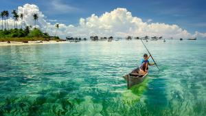 a person in a boat in the water at Zero Gravity Homestay 零重力民宿 in Semporna
