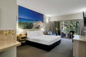 a hotel room with a bed and a view of the ocean at Kingfisher Bay Resort in K'gari Island (Fraser Island)