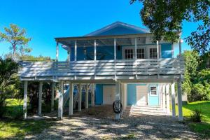 a house with a large wooden porch with a garage at Casa Arena Relaxing Beach House w/ Patio in Vero Beach