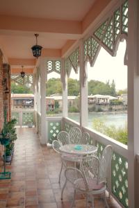 een afgeschermde veranda met een tafel en stoelen bij Hotel Paradise Road in Koetaisi