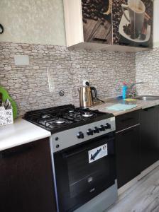 a kitchen with a black stove and a sink at Квартира 5-9 in Aktau +4 photos