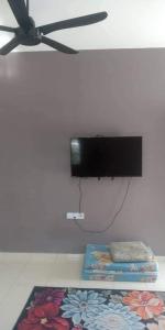 um quarto com dois tapetes e uma televisão na parede em Ema roomstay em Jementah