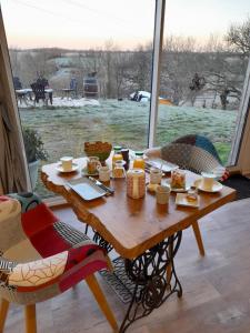stół z jedzeniem przed oknem w obiekcie Maison Dougnac w mieście Fleurance