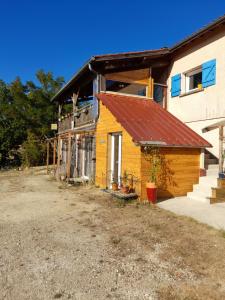 una casa amarilla con un techo oxidado en un edificio en Maison Dougnac en Fleurance