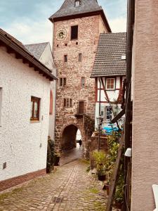 un ancien bâtiment en pierre avec une tour d'horloge dans l'établissement Natur und Neckarblick bei Heidelberg, à Hirschhorn