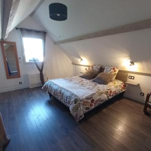 1 dormitorio con 1 cama grande y ventana en Gîte L'Albizia Saint Maurice en Saint-Maurice-en-Rivière