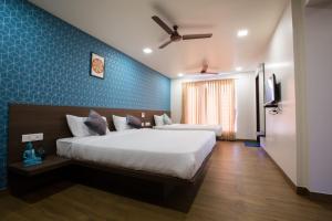 a bedroom with a large bed and a blue wall at HOTEL VINTAGE CASTLE in Coimbatore