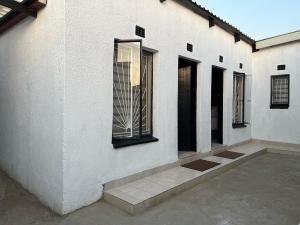un edificio blanco con una ventana en el costado en Maponya Guest House, en Pimville