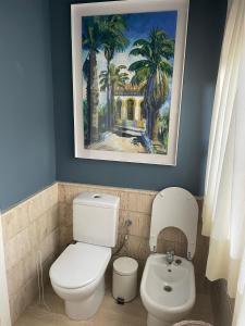 baño con aseo y una pintura en la pared en Espléndido dormitorio en Suite, en Fuente el Saz