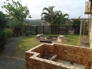 eine Backsteinmauer mit einer Feuerstelle im Hof in der Unterkunft East-Coast Guesthouse: Serene, Private, Secure in Durban