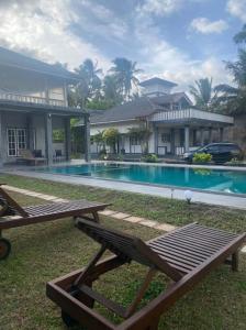 - une piscine en face d'une maison dans l'établissement Rosanuka Beach Villa, à Wayikkal