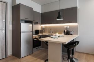 a kitchen with black cabinets and a white counter top at Porto Pireo in Piraeus