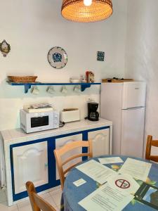 uma cozinha com uma mesa, um micro-ondas e um frigorífico em La Casita Blanca- La Almona Chica em El Chorro