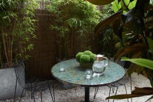a glass table with a vase of broccoli on it at No.5 Maddox Street in London