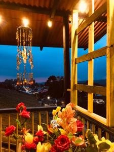 a vase of flowers on a balcony with a chandelier at Hostal Salento Sunset in Salento +22 photos