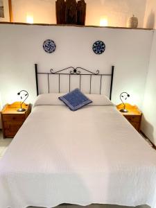 エル・チョロにあるLa Casita Blanca- La Almona Chicaのベッドルーム(白い大型ベッド、ランプ2つ付)