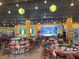 Khách sạn Vườn Cau & Khu vui chơi giải trí SaLa في Tây Ninh: غرفة طعام مع طاولات وكراسي وأضواء