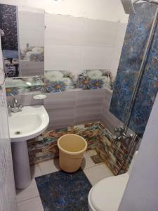 uma casa de banho com um lavatório, um chuveiro e um WC. em Doha Guest House 