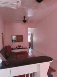 a living room with pink walls and a white table at Narayana Illam in Nilai