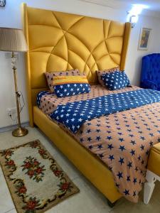 1 dormitorio con 1 cama grande y cabecero amarillo en The Residence Golden Tulip 2 Bedroom Apartment, Amuwo Lagos, Nigeria en Lagos